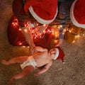 A family with a newborn baby at the Christmas tree in the evening living room. Unfree parents with a small child on New Year Eve Royalty Free Stock Photo