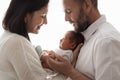 Family with Newborn Baby. Happy Parents holding one month Child. Smiling Mother and Father Silhouette with Infant over White Royalty Free Stock Photo