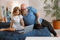 Family of obese father and cute little daughter at videochat via modern computer sits on bed Royalty Free Stock Photo