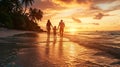 A family with one child walks along a beach on a tropical island at sunset, seen from behind Royalty Free Stock Photo