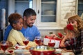 Family opening Christmas presents at table Royalty Free Stock Photo