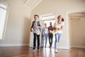 Family Opening Door And Walking In Empty Lounge Of New Home