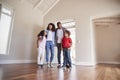 Family Opening Door And Walking In Empty Lounge Of New Home