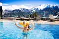 Family in outdoor swimming pool of alpine spa resort Royalty Free Stock Photo