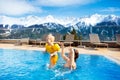 Family in outdoor swimming pool of alpine spa resort Royalty Free Stock Photo