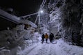 Family outdoor together at winter night, beautiful snowy landscape in countryside, group of people in street light Royalty Free Stock Photo