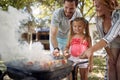 Family outdoors on garden barbecue, grilling