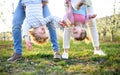 Family outdoors in orchard in spring, holding children upside down. Royalty Free Stock Photo