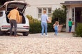 Family Outside New Home On Moving Day Loading Or Unloading Boxes From Car Royalty Free Stock Photo