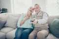 Family of pair aged people spending free time together changing channels found humorous show sit sofa