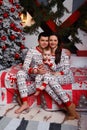 Family in pajamas sits on a bed near the Christmas tree mom, dad and toddler, idyll, Christmas celebration. family happiness Royalty Free Stock Photo