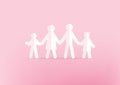 Family paper holding hands on pink background. Happy family concept.