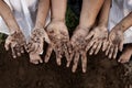 Family parent and children showing dirty hands after planting the tree together