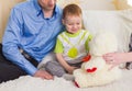 Family, parenthood and children concept - Close-up of happy mother, father and son playing together with teddy bear on Royalty Free Stock Photo