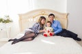 Family, parenthood and children concept - Happy mother, father and son playing together with teddy bear on bed in Royalty Free Stock Photo