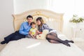 Family, parenthood and children concept - Happy mother, father and son playing together with teddy bear on bed in Royalty Free Stock Photo