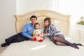 Family, parenthood and children concept - Portrait of happy mother, father and son sitting together on bed in bedroom at Royalty Free Stock Photo