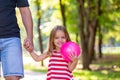 Family, parenthood, fatherhood, adoption and people concept - happy father and little girl walking holding in hand in Royalty Free Stock Photo