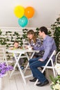 Family, parenthood, happy birthday and holiday concept - happy parents and child at a table drinking tea and eating cake Royalty Free Stock Photo