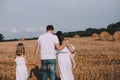 family parents children field stacks straw autumn