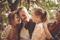 Family in park having conversation and hugging.