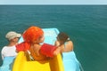 Family on pedal boat with slide in sea