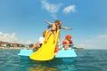 Family on pedal boat with yellow slide in sea