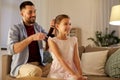 Father brushing daughter hair at home