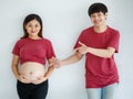 Family, people lifestyle concept. A beautiful young Asian pregnant lady smiling standing with a happy man against white background Royalty Free Stock Photo