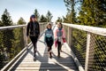 Family people walking wooden treetop bridge canopy walkway in winter