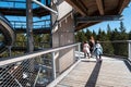 Family people walking wooden treetop observation deck walkway in winter