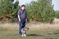 Family, pet, animals and people concept - happy man with schnauzer dog walking in city park. Profile shot Royalty Free Stock Photo