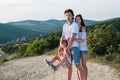 Family photo in the mountains mom, dad and son wearing light clothing. Son hanging in dad`s hands. Royalty Free Stock Photo