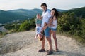 Family photo in the mountains with kid wearing light clothing Son hanging in dad`s hands upside down Royalty Free Stock Photo
