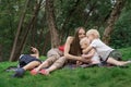 Family picnic at gaden park outdoors. Mom and three children rest on picnic blanket