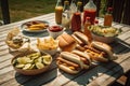 a family picnic, with hot dogs, buns, and condiments on the table