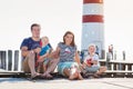 Family on the pier at the lighthouse, sunny summer day