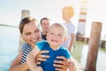 Family on the pier at the lighthouse, sunny summer day