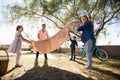 Family placing picnic blanket on in the park