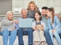 Family planning. Shot of a family using a laptop while sitting on a sofa together at home. Royalty Free Stock Photo