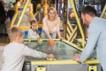 family playing air hockey together in entertainment