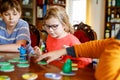 Family playing board game at home. Kids play strategic game. Little sister girl and two school brothers boys. Fun indoor Royalty Free Stock Photo