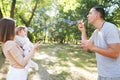 Family playing with bubbles outdoors in the park Royalty Free Stock Photo