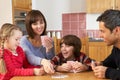 Family Playing Cards In Kitchen Royalty Free Stock Photo