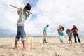 Family playing cricket on beach Royalty Free Stock Photo