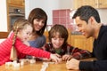 Family Playing Dominoes In Kitchen Royalty Free Stock Photo