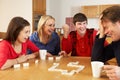 Family Playing Dominoes In Kitchen