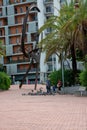 Family playing and feeding pidgeons next to sculpture in Barcelona