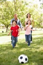 Family playing football in park Royalty Free Stock Photo