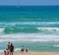 A family playing in the sand and waves of the Mediterranean Sea at Ashkelon, Israel.